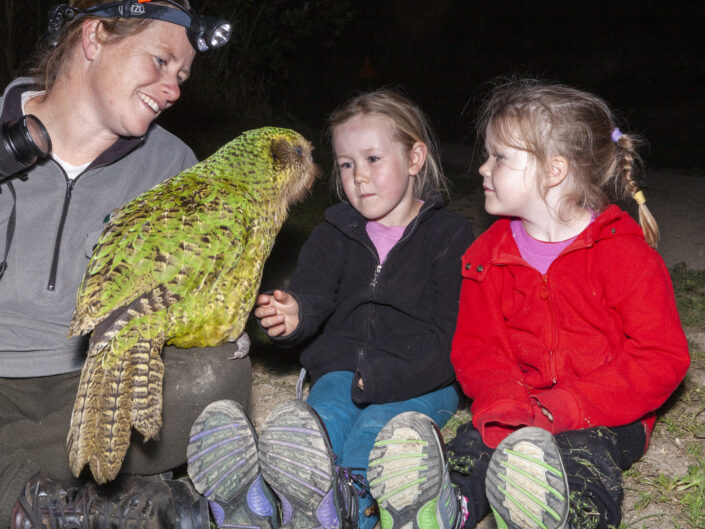 Ros, Hannah et Tanya Cole rencontrent Sirocco, le fameux perroquet Kakapo ambassadeur, sur l'île de Maud, Aotearoa Nouvelle-Zélande